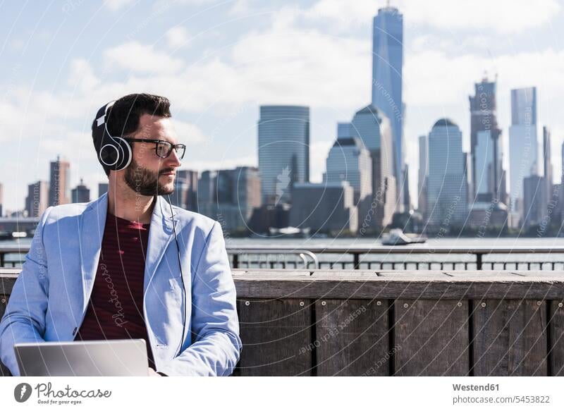 USA, Mann mit Kopfhörern und Tablet am Hafen von New Jersey mit Blick auf Manhattan Tablet Computer Tablet-PC Tablet PC iPad Tablet-Computer Männer männlich