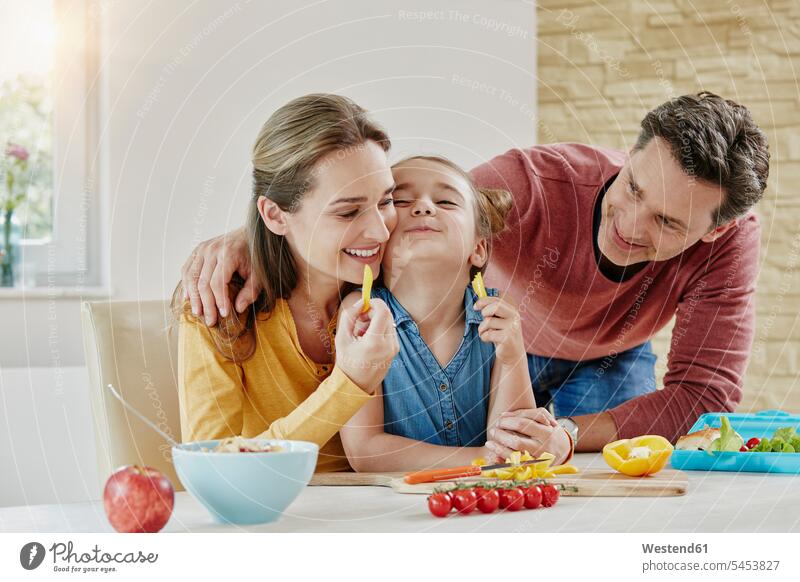 Glückliche Familie zu Hause, die gesundes Essen zubereitet Tochter Töchter Familien lächeln Gemüse Gemuese glücklich glücklich sein glücklichsein essen essend