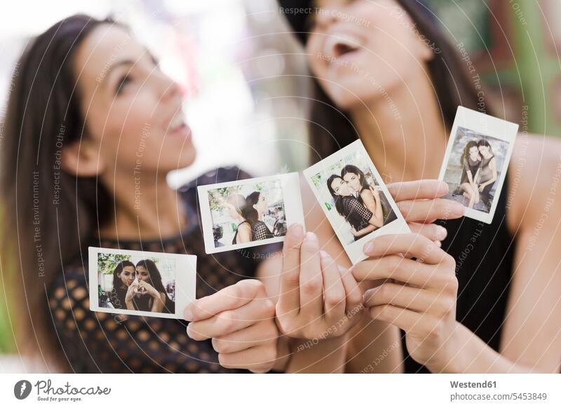 Zwei glückliche Zwillingsschwestern mit Sofortfotos von sich selbst Foto Fotos Freundinnen Schwester Schwestern Bild Bildnis Bilder Freunde Freundschaft