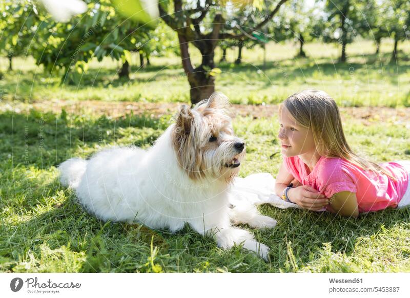Mädchen liegt mit Hund auf der Wiese Garten Gärten Gaerten Hunde glücklich Glück glücklich sein glücklichsein liegen liegend Wiesen weiblich Haustier Haustiere