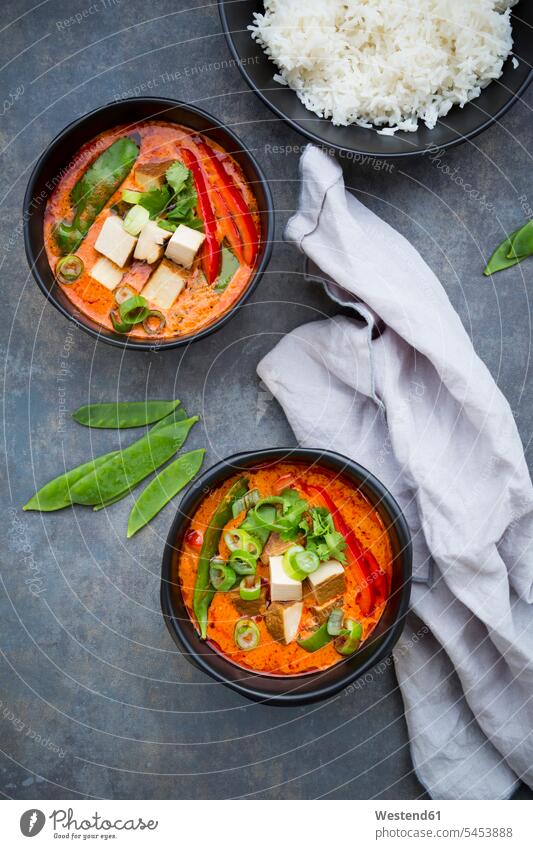 Zwei Schüsseln rotes Thai-Curry mit Zuckerschoten, Karotten, Paprika, Frühlingszwiebeln und geräuchertem Tofu Gemuesepaprika Gemüsepaprika Paprikas