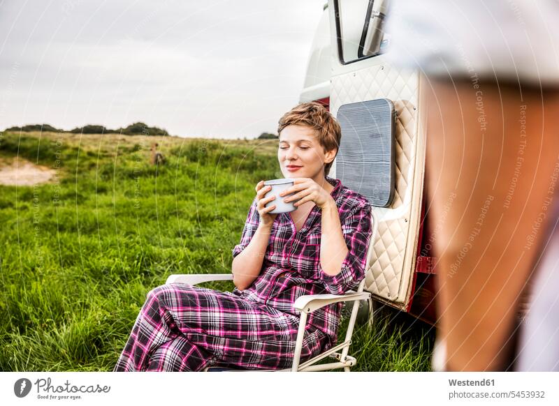 Frau im Pyjama genießt Kaffee in einem Lieferwagen auf dem Land weiblich Frauen Kleinbus Kleinbusse Getränk Getraenk Getränke Getraenke Food and Drink