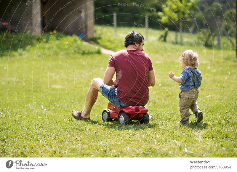 Vater und sein kleiner Sohn spielen draußen zusammen Söhne Papas Väter Vati Vatis Papis Garten Gärten Gaerten Kind Kinder Familie Familien Mensch Menschen Leute