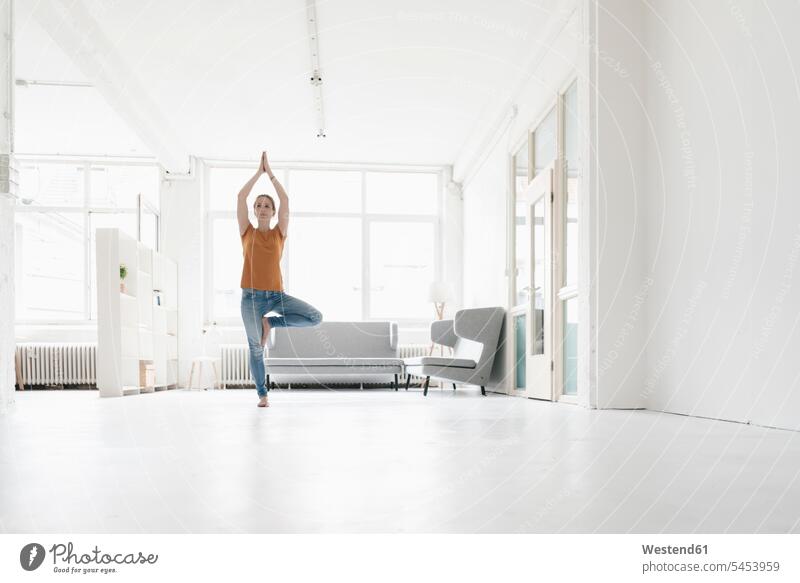 Frau praktiziert Yoga auf einem Dachboden weiblich Frauen Loft Lofts Yoga-Übungen Yogauebungen Yogaübungen Jogauebung Jogauebungen Erwachsener erwachsen Mensch