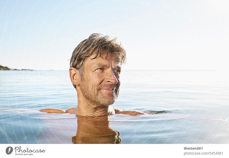 Porträt eines lächelnden Mannes beim Baden im Meer Meere Männer männlich Portrait Porträts Portraits baden Gewässer Wasser Erwachsener erwachsen Mensch Menschen