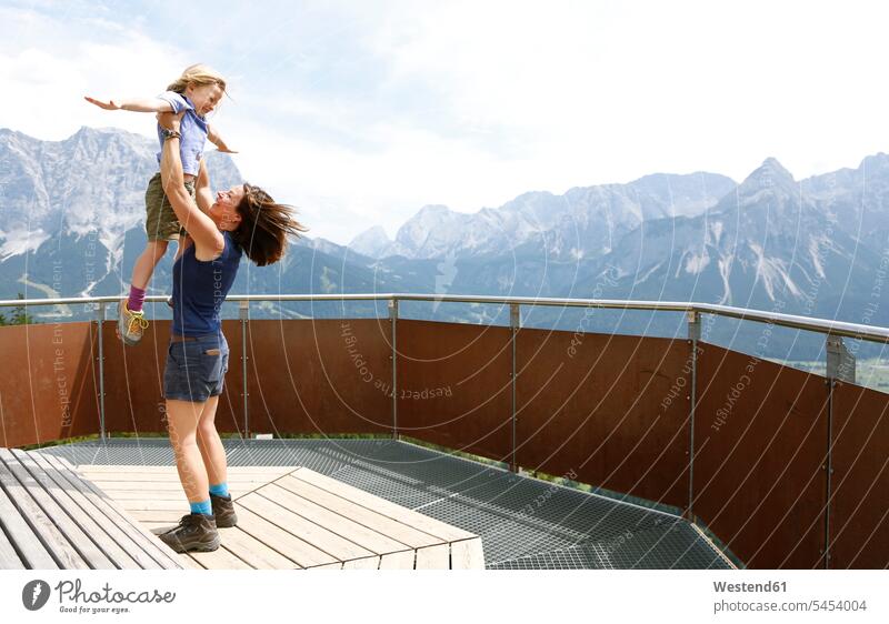Österreich, Südtirol, Mutter hebt ihre Tochter hoch drehen Drehung hochheben Aussichtspunkt Freude freuen Töchter jubeln Jubel Mami Mutti Mütter Mama Kind