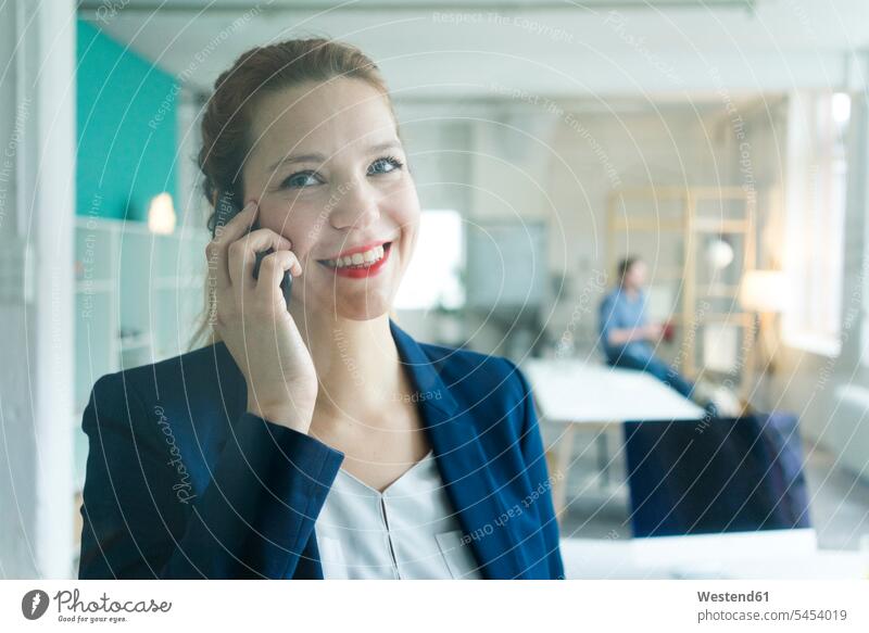 Lächelnde Geschäftsfrau beim Telefonieren glücklich Glück glücklich sein glücklichsein telefonieren anrufen Anruf telephonieren Handy Mobiltelefon Handies