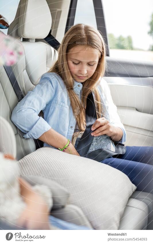 Im Auto sitzendes Mädchen, Sicherheitsgurt anlegen angeschnallt sitzt anschnallen Urlaub Ferien Autoreise Sicherheitsgurte Anschnallgurt Anschnallgurte weiblich