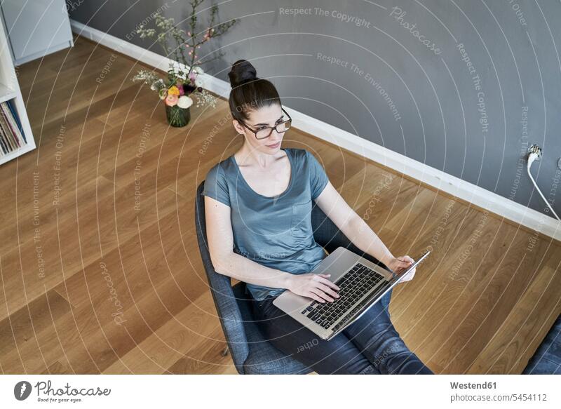 Junge Frau benutzt Laptop zu Hause sitzen sitzend sitzt weiblich Frauen Notebook Laptops Notebooks Erwachsener erwachsen Mensch Menschen Leute People Personen