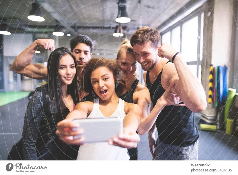 Eine Gruppe junger Leute posiert für ein Selfie in einer Turnhalle Sportlerin Sportlerinnen Freunde Selfies Handy Mobiltelefon Handies Handys Mobiltelefone