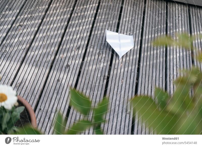 Papierhobel auf Holzterrasse Terrasse Terrassen Papierflieger Papierflugzeug Spielzeug Außenaufnahme draußen im Freien Tag am Tag Tageslichtaufnahme tagsueber