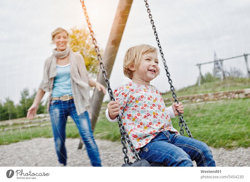 Mutter mit Tochter auf Schaukel auf dem Spielplatz Schaukeln lachen Mami Mutti Mütter Mama Töchter Spielplätze Spielfeld Spielplaetze glücklich Glück