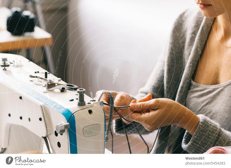 Nahaufnahme einer Frau mit Nähmaschine arbeiten Arbeit Schneiderin Schneiderinnen weiblich Frauen nähen naehen Nähmaschinen Naehmaschinen Handwerker