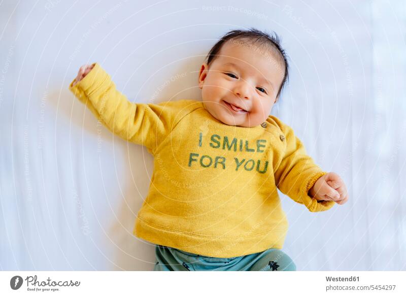 Glückliches kleines Mädchen lächelt auf dem Bett lächeln liegen liegend liegt Kind Babies Babys Kinder Mensch Menschen Leute People Personen Betten Entspannung