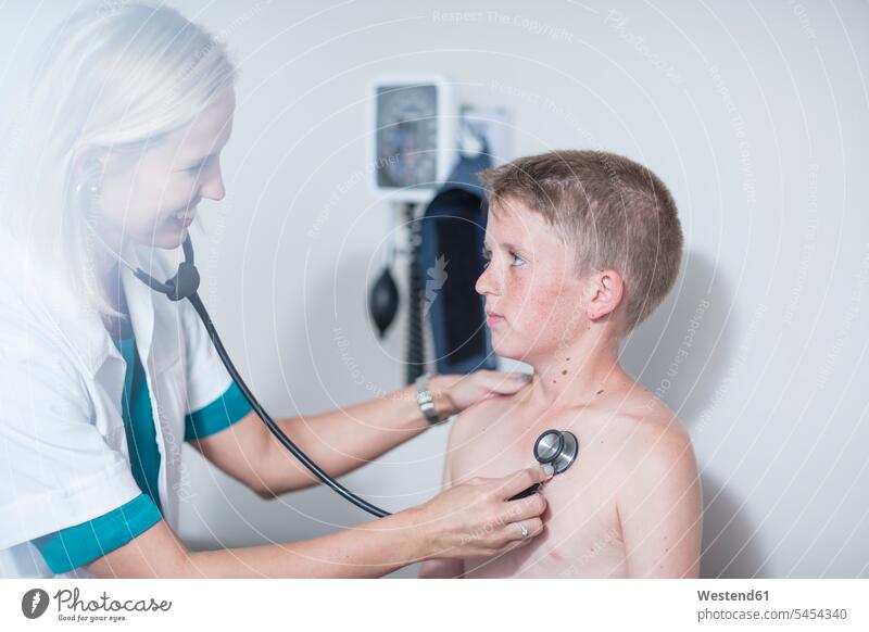 Weibliche Pädiaterin untersucht die Lunge eines Jungen mit dem Stethoskop Abhören abhorchen Auskultation abhoeren Stethoskope Buben Knabe Knaben männlich