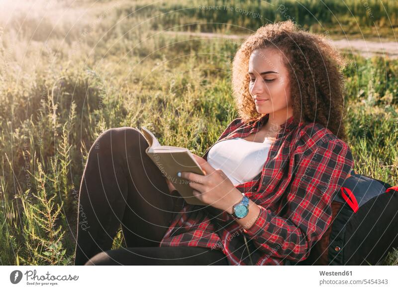 Teenagerin liest Buch auf einer Wiese Bücher junges Mädchen Teenagerinnen weiblich junge Frau Portrait Porträts Portraits Jugendliche Heranwachsende