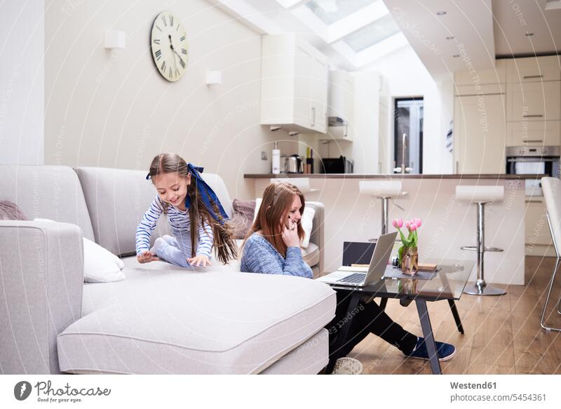 Kleines Mädchen spielt auf der Couch, während ihre Mutter per Handy telefoniert Mami Mutti Mütter Mama Doppelbelastung arbeiten Arbeit Anruf Kind Kinder Kids