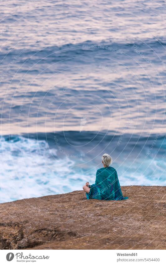 Indonesien, Lombok, Frau sitzt an der Küste und schaut auf die Aussicht Kueste Kuesten Küsten sitzen sitzend Meer Meere weiblich Frauen Ausblick Ansicht