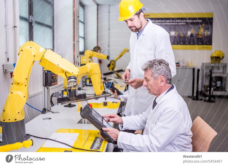 Zwei Ingenieure in der Fabrik sehen sich das Gerät an Mann Männer männlich Roboter Kollegen Arbeitskollegen Fabriken Erwachsener erwachsen Mensch Menschen Leute