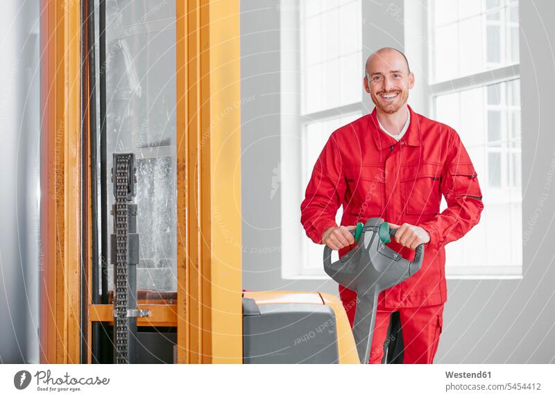Porträt eines lächelnden Mannes in der Fabrik mit Gabelstapler Fabriken Männer männlich Lager arbeiten Arbeit Erwachsener erwachsen Mensch Menschen Leute People