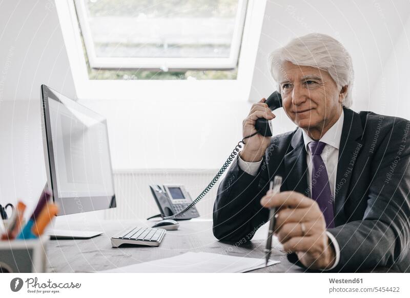 Leitender Geschäftsmann am Telefon an seinem Schreibtisch Businessmann Businessmänner Geschäftsmänner Portrait Porträts Portraits Büro Office Büros telefonieren