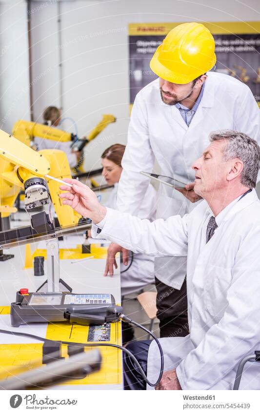 Zwei Ingenieure untersuchen Industrieroboter Roboter Kollegen Arbeitskollegen Fabrik Fabriken Mann Männer männlich Technik Techniken Technologie Erwachsener