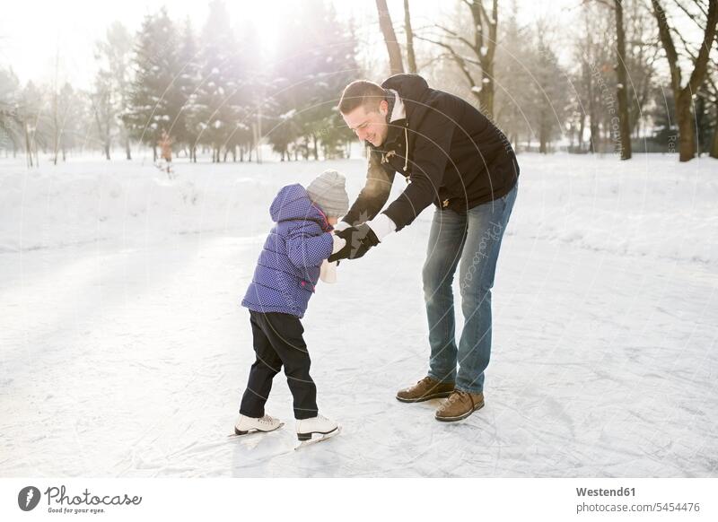 Vater und Tochter eislaufen auf gefrorenem See Töchter Papas Väter Vati Vatis Papis vereist eingefroren zugefroren schlittschuhlaufen Seen Schlittschuhlaufen