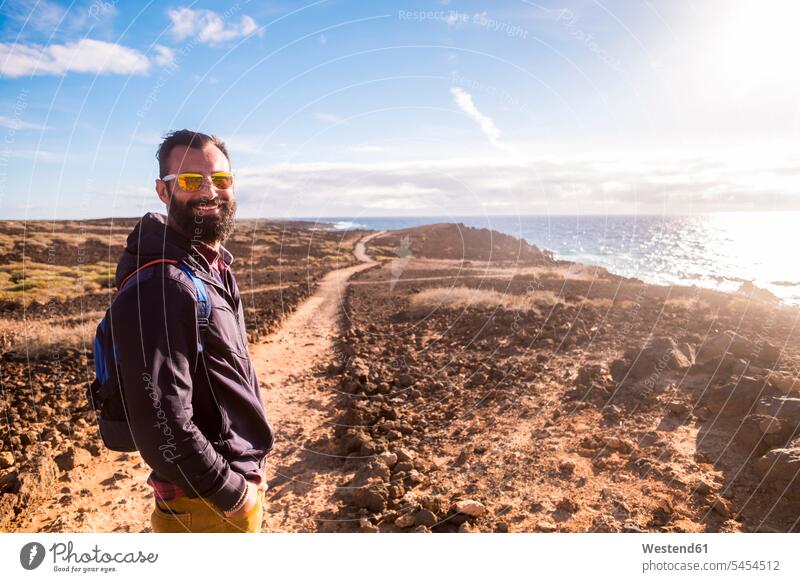 Spanien, Teneriffa, Porträt eines glücklichen Wanderers im Sonnenlicht Mann Männer männlich Erwachsener erwachsen Mensch Menschen Leute People Personen stehen