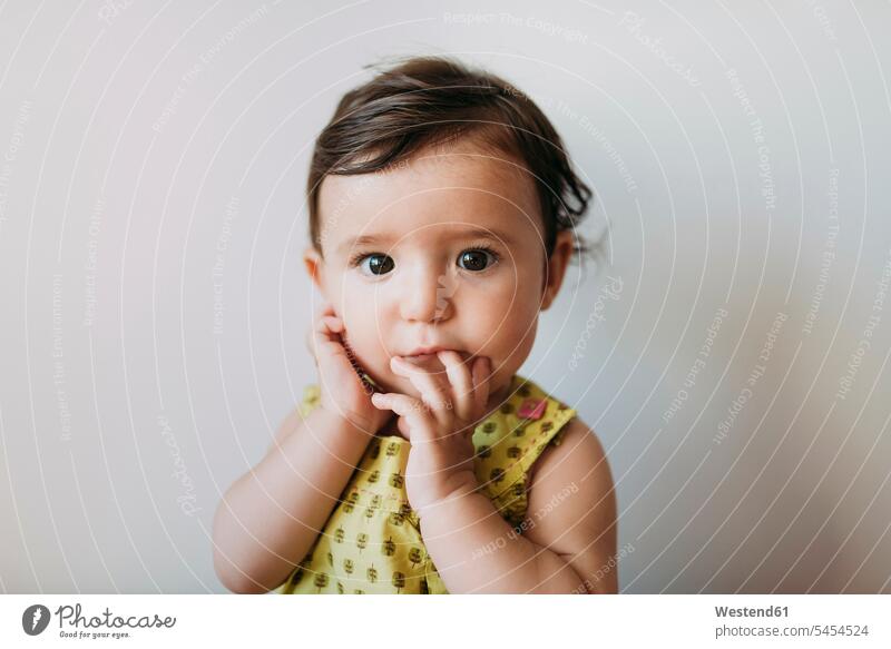 Bildnis eines kleinen Mädchens mit Hand auf Mund auf weißem Hintergrund Portrait Porträts Portraits Baby Babies Babys Säuglinge Kind Kinder Mensch Menschen