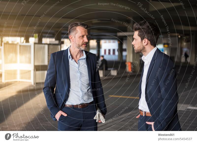 Zwei Geschäftsleute im Gespräch am Busbahnhof Geschäftsmann Businessmann Businessmänner Geschäftsmänner Geschäftspersonen Geschäftsleben Geschäftswelt