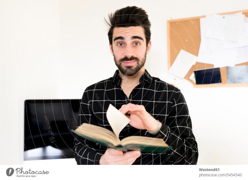 Porträt eines Mannes, der ein Buch hält Bücher Männer männlich Erwachsener erwachsen Mensch Menschen Leute People Personen Bart Bärte Student Hochschueler