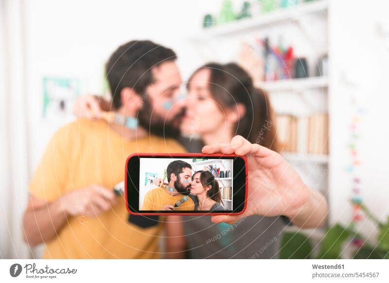 Junges Paar, das sich küsst und ein Selfie mit Pinseln macht Selfies Handy Mobiltelefon Handies Handys Mobiltelefone küssen Küsse Kuss Pärchen Paare