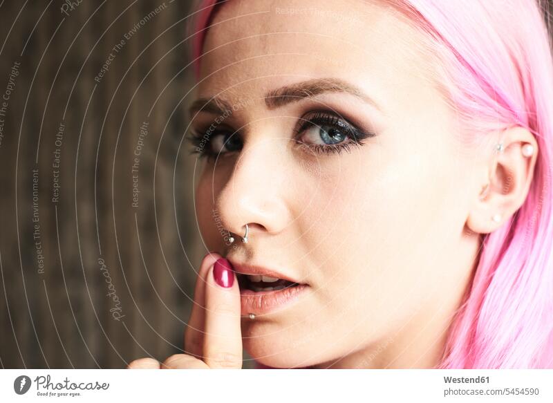 Porträt einer jungen Frau mit rosa Haaren und Piercings ernst Ernst Ernsthaftigkeit ernsthaft weiblich Frauen Portrait Porträts Portraits Erwachsener erwachsen