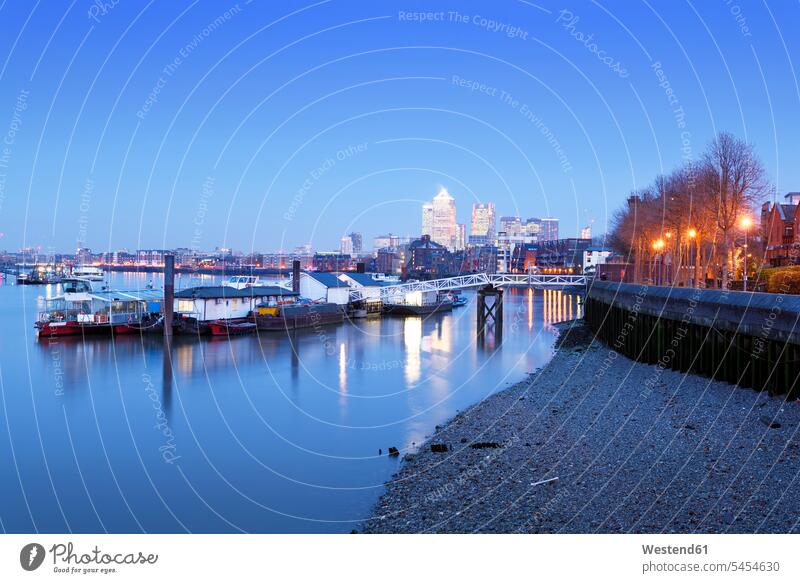 Großbritannien, London, schwimmende Werkstätten auf der Themse und Canary Wharf im Hintergrund zur blauen Stunde Abend abends Skyline Skylines Städtisches Motiv