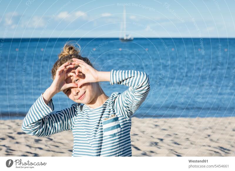 Mädchen am Strand schaut durch den Fingerrahmen Europäer Kaukasier Europäisch kaukasisch Sand sandig Tag am Tag Tageslichtaufnahme tagsueber Tagesaufnahmen