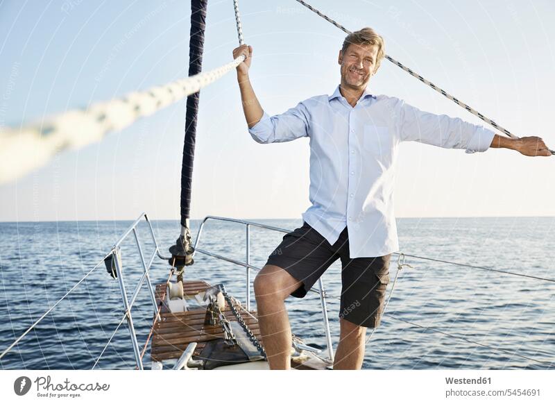 Porträt eines lächelnden reifen Mannes auf seinem Segelboot Männer männlich Segeln segelnd segelt Portrait Porträts Portraits Erwachsener erwachsen Mensch