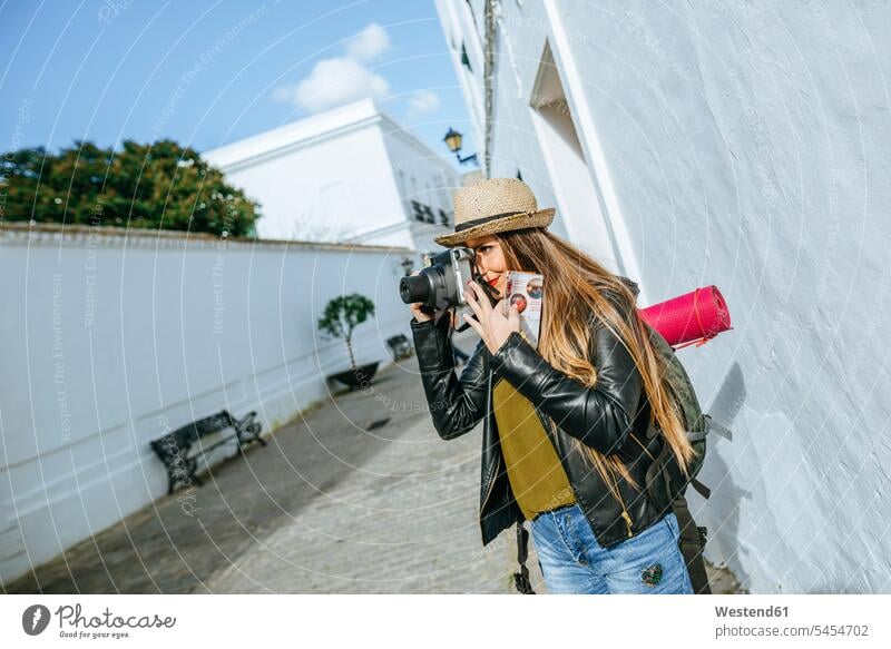 Junge reisende Frau fotografiert in einer Stadt Fotoapparat Kamera Fotokamera fotografieren weiblich Frauen Erwachsener erwachsen Mensch Menschen Leute People