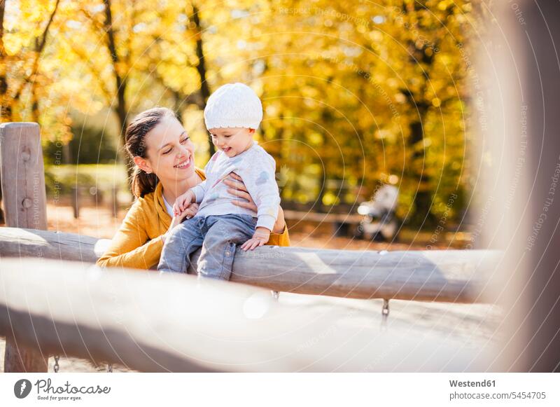 Glückliches kleines Mädchen und ihre Mutter haben im Herbst Spaß auf einem Spielplatz Spielplätze Spielfeld Spielplaetze weibliche Babys weibliches Baby