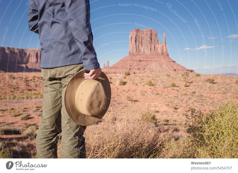 USA, Utah, Junger Mann betrachtet Monument Valley Tourist Touristen fasziniert Faszination Abenteuer abenteuerlich stehen stehend steht halten Hut Hüte