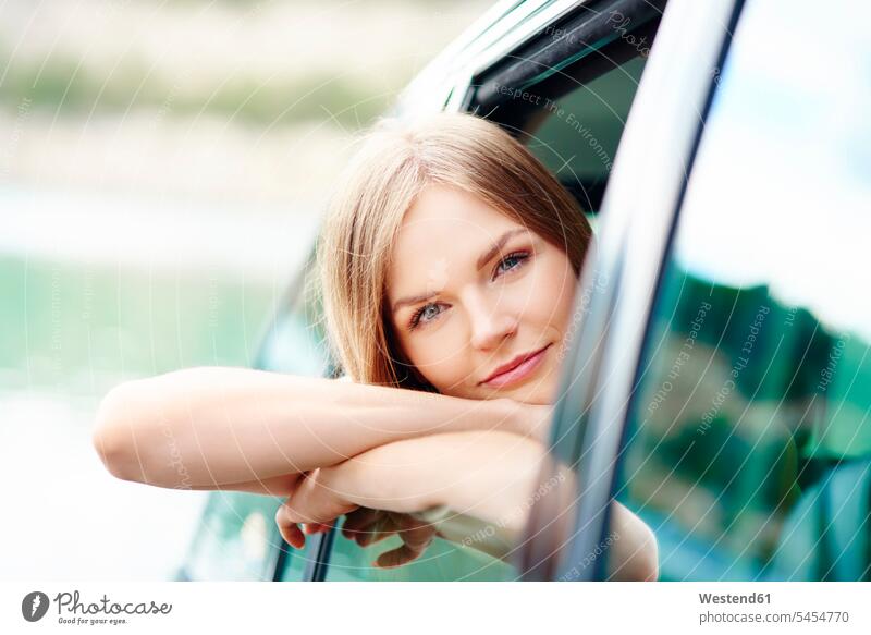 Porträt einer jungen Frau, die sich aus dem Autofenster lehnt Wagen PKWs Automobil Autos Fenster weiblich Frauen Kraftfahrzeug Verkehrsmittel KFZ Verkehrswesen