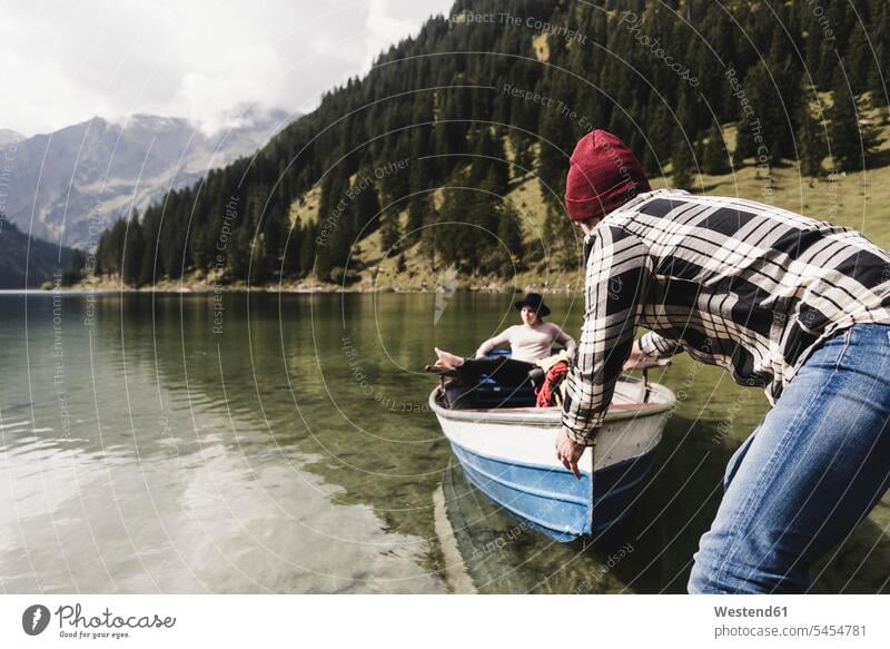 Österreich, Tirol, Alpen, Paar mit Ruderboot auf Bergsee See Seen Pärchen Paare Partnerschaft entspannt entspanntheit relaxt Boot Boote Gewässer Wasser Mensch