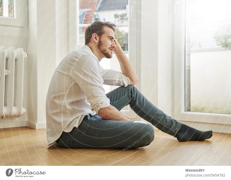 Auf dem Boden sitzender Mann Männer männlich sitzt Erwachsener erwachsen Mensch Menschen Leute People Personen Zuhause zu Hause daheim entspannt entspanntheit