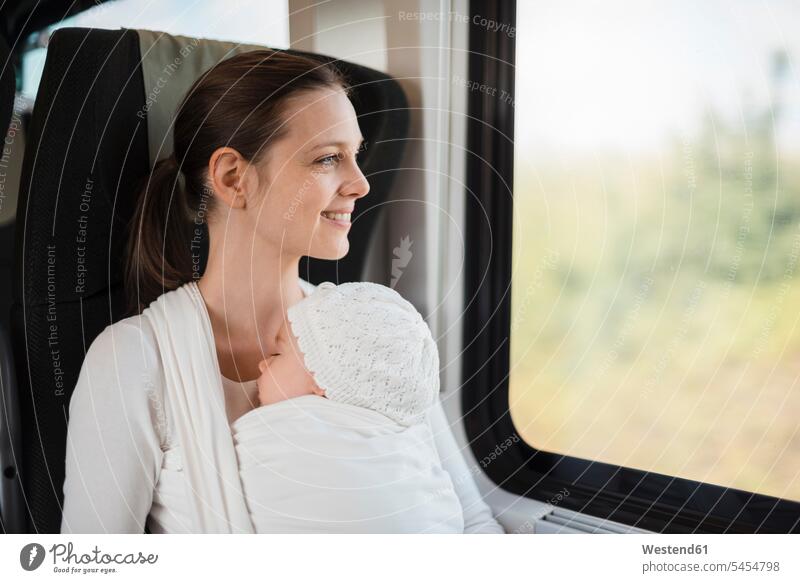 Mutter mit Mädchen reist mit dem Zug und schaut aus dem Fenster Baby Babies Babys Säuglinge Kind Kinder Mami Mutti Mütter Mama reisen verreisen lächeln Bahnen