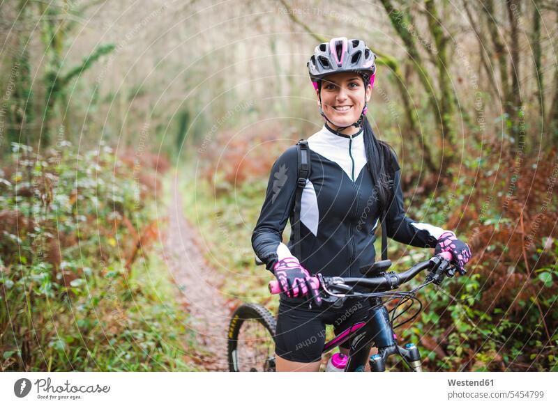 Porträt einer lächelnden Frau mit Mountainbike im Wald Mountainbikes Mountainbiking mountainbiken MTB weiblich Frauen Fahrrad Bikes Fahrräder Räder Rad Raeder