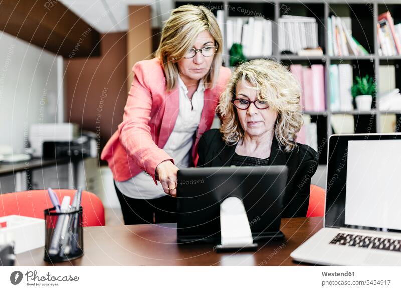 Zwei Geschäftsfrauen mit Laptop am Schreibtisch im Büro Office Büros Businesswomen Businessfrauen Businesswoman Notebook Laptops Notebooks Kollegin Kolleginnen