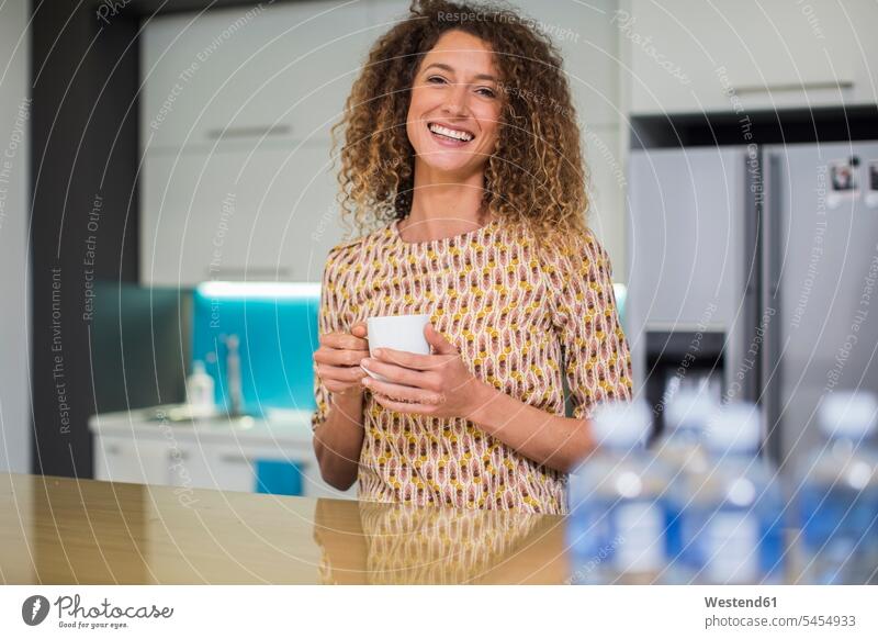 Porträt einer lächelnden Frau in einer Büroküche, die eine Tasse hält Pause Portrait Porträts Portraits Kaffee Küche Getränk Getraenk Getränke Getraenke