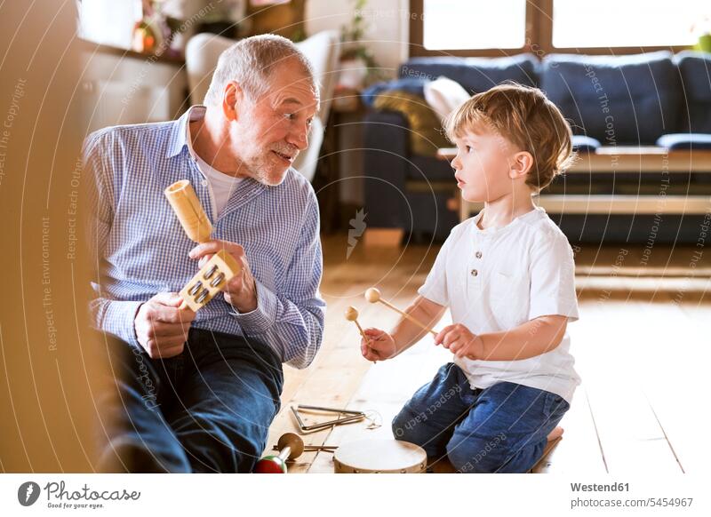 Großvater und Enkel musizieren zu Hause Zuhause daheim Musik spielen lernen Enkelsöhne Enkelsohn Gemeinsam Zusammen Miteinander Opa Großpapa Großpapas Opas Opi