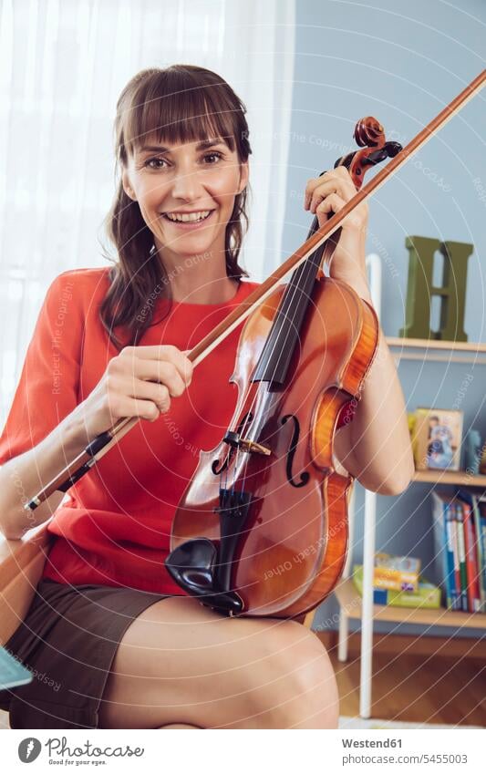 Bildnis einer Frau mit Geige im Kinderzimmer spielen lächeln Violine Geigen Violinen üben ausüben Übung trainieren weiblich Frauen Streichinstrument