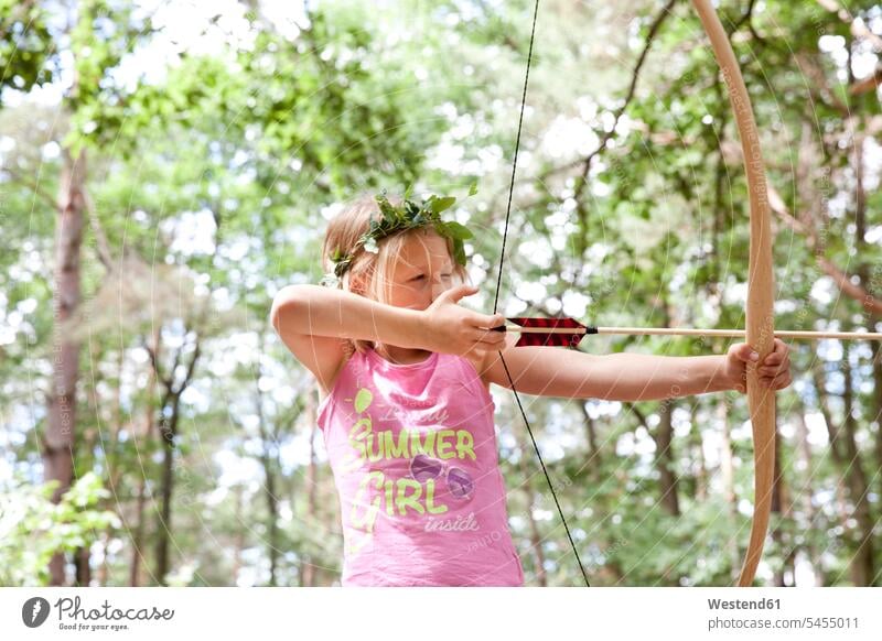 Mädchen beim Schießen mit Pfeil und Bogen im Wald Pfeile weiblich schießen Forst Wälder Bogenschießen Bogenschiessen Kind Kinder Kids Mensch Menschen Leute