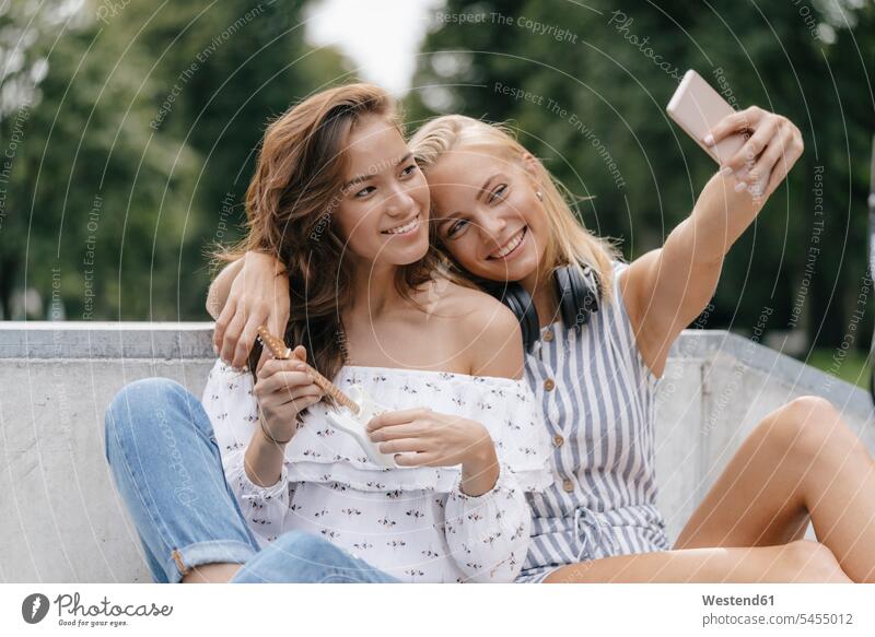 Zwei glückliche junge Frauen machen ein Selfie in einem Skatepark Freundinnen Skateboardpark Skateboard-Park Skateboard Park Skaterplatz Glück glücklich sein